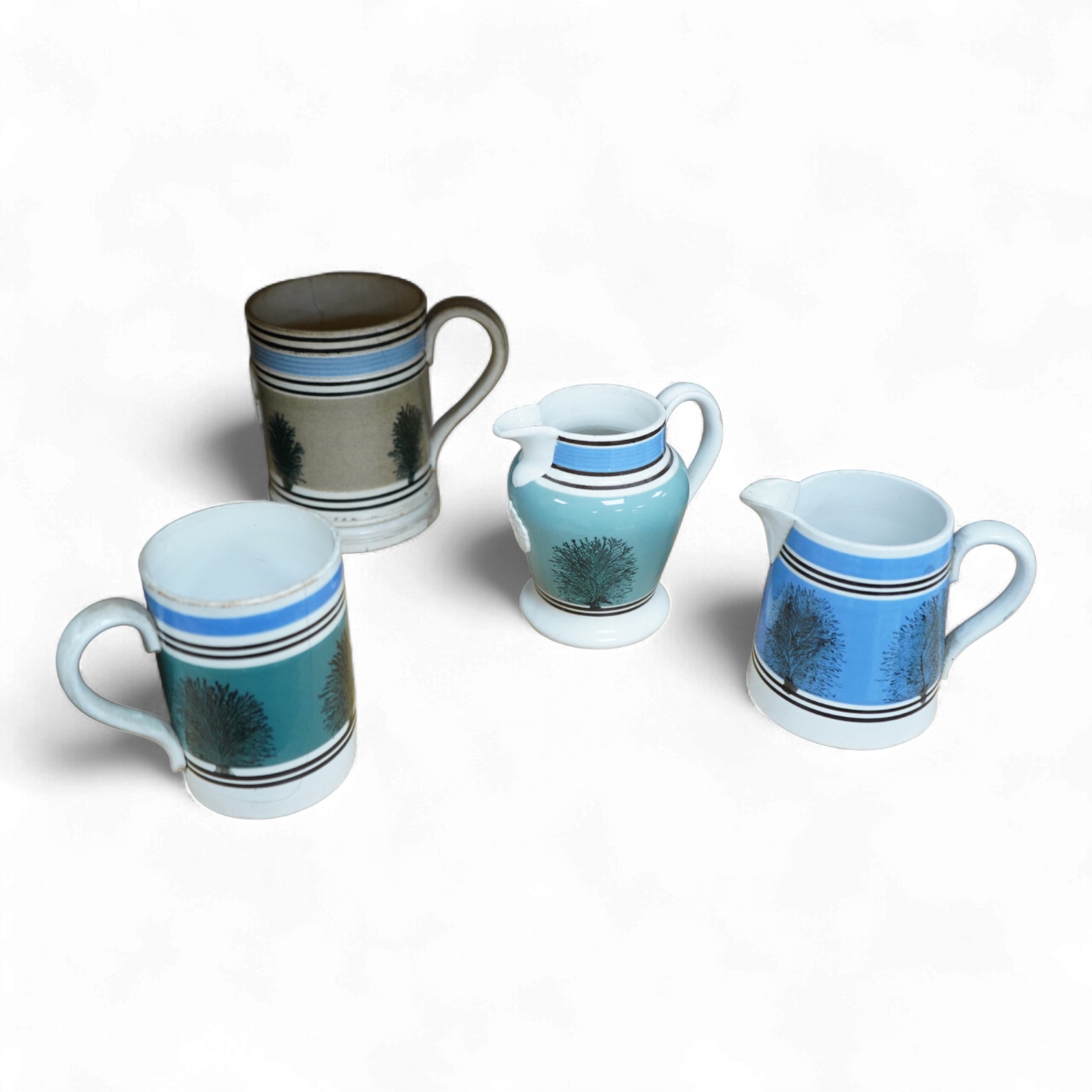 Two early 19th century Mocha ware jugs and two mugs, largest 16cm high